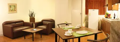 a kitchen and living room with a table and chairs at Riviera Mansion Hotel in Manila