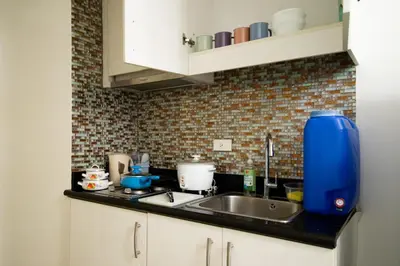 a kitchen with a sink and a blue jug on the counter at SNAPz Staycation @ Jazz Residences in Manila