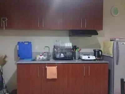 a kitchen with wooden cabinets and a counter top at Mmr in Manila