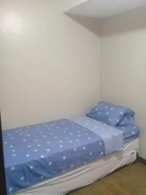 a small bedroom with a bed with blue sheets at Mmr in Manila