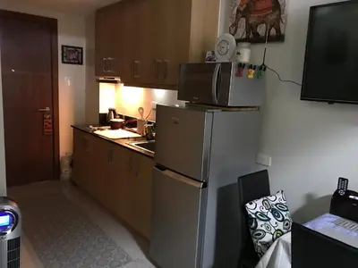 a kitchen with a microwave on top of a refrigerator at BEST Q CONDO w/ Great View in Manila
