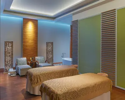 a room with two beds and chairs in it at Grand Hyatt Manila in Manila