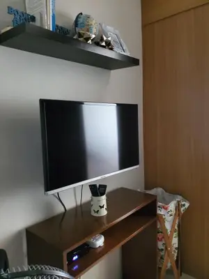 a flat screen tv sitting on top of a wooden table at Shell Residence Manila in Manila