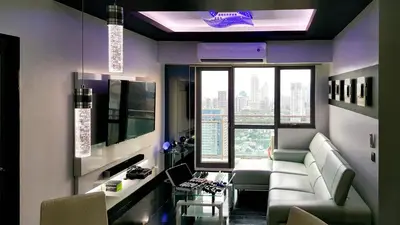 a living room with a couch and a table with chairs at Modern Luxury Lower Penthouse Unit in Manila