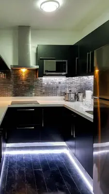 a kitchen with black cabinets and black appliances at Modern Luxury Lower Penthouse Unit in Manila