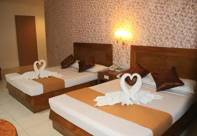 two beds in a hotel room with swans on them at Rosas Garden Hotel in Manila