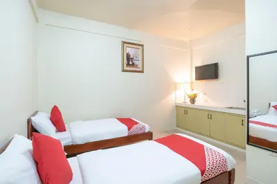 a small room with two beds and a television at Conrado's Apartelle in Manila