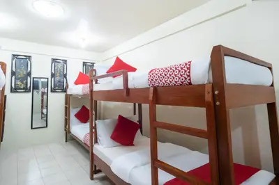 a room with two bunk beds with red pillows at Conrado's Apartelle in Manila