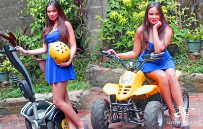 two women in blue dresses sitting on a quad bike at White Knight Hotel Intramuros in Manila