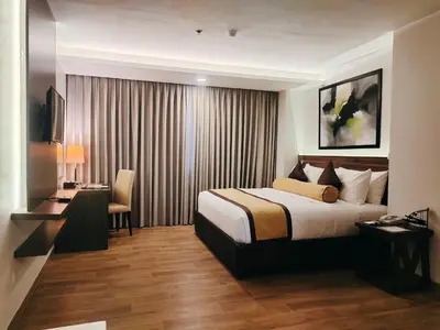 a hotel room with a bed and a desk at Hotel Marciano in Calamba