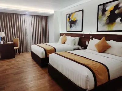 a hotel room with two beds and a desk at Hotel Marciano in Calamba