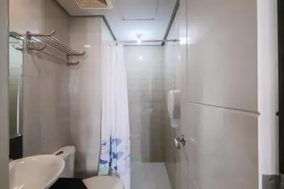 a bathroom with a shower and a toilet and a sink at Tess and Tessha Condotel near T3 Airport in Manila