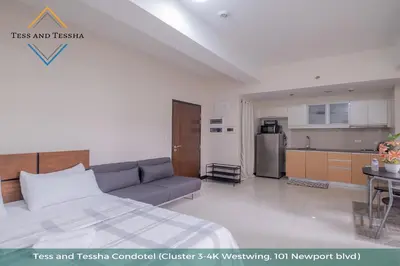 a living room with a bed and a kitchen at Tess and Tessha Condotel near T3 Airport in Manila