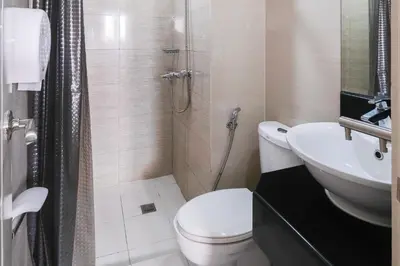 a bathroom with a toilet and a sink at Tess and Tessha Condotel near T3 Airport in Manila