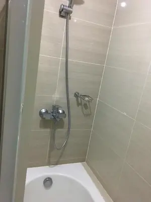a shower in a bathroom with a toilet at De Luxe 7QRS in Manila