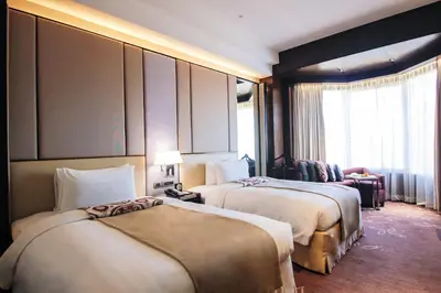 a hotel room with two beds and a living room at Diamond Hotel Philippines in Manila