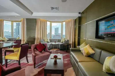 a living room with a couch and a tv at Diamond Hotel Philippines in Manila
