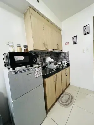 a kitchen with a refrigerator and a microwave at Sea Breeze Studio Manila in Manila