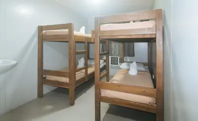 two bunk beds in a room with a sink at Metro Deluxe Residences near World Trade Center in Manila