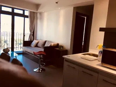 a living room with a couch and a desk with a computer at Portovita Towers in Manila