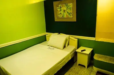 a small green room with a bed and a stool at Dreamwave Resort Pansol Laguna in Calamba