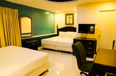 a hotel room with two beds and a desk and a chair at Dreamwave Resort Pansol Laguna in Calamba