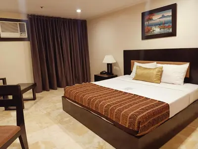 a bedroom with a large bed in a room at Paragon Tower Hotel in Manila
