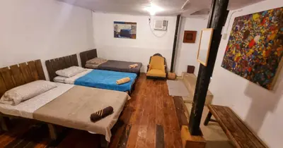 a room with two beds and a painting on the wall at Marius B&B & Hostel in Silang
