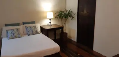 a bedroom with a bed and a table with a lamp at Marius B&B & Hostel in Silang