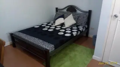 a small bed with black and white pillows on it at The Terrace Room in Manila