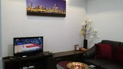 a living room with a tv and a couch at Burgundy McKinley Place in Manila