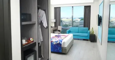 a hotel room with a blue couch and a chair at Savoy Hotel Manila near Airport NAIA Terminal 3 MNL in Manila