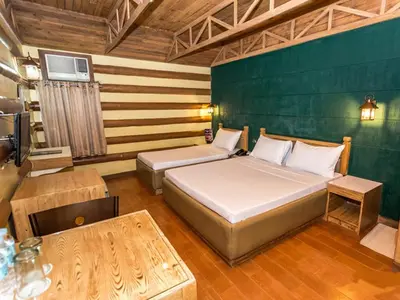 a bedroom with two beds and a table at Urban Travellers Hotel in Manila