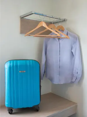 a blue suitcase and a shirt in a closet at Hop Inn Hotel Aseana City Manila in Manila