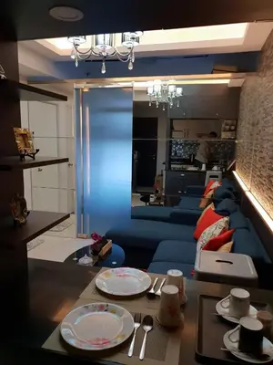 a living room with a table with plates and utensils at Your HOME @ Princeton Residences, New Manila in Manila