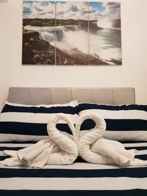 two white swans sitting on top of a bed at Your HOME @ Princeton Residences, New Manila in Manila