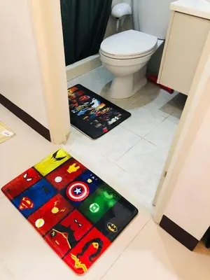 a bathroom with a toilet and a rug on the floor at Pine Crest Condominium in Manila