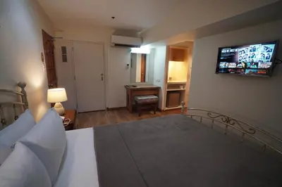 a bedroom with a bed with a television on the wall at 1775 Adriatico Suites in Manila