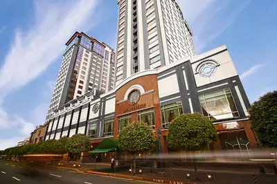 a building on a street with two tall buildings at The Bellevue Manila in Manila
