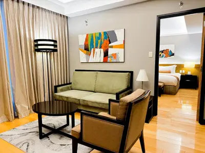 a living room with a couch and a table at The Bellevue Manila in Manila