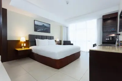a hotel room with a bed and a kitchen at The B Hotel Alabang in Manila