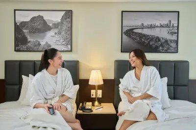 two women sitting on beds in a hotel room at The B Hotel Alabang in Manila