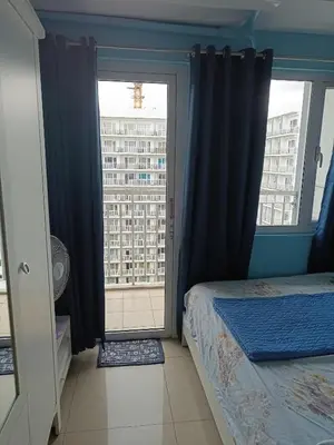 a bedroom with a bed and a large window at Shell Residences in Manila