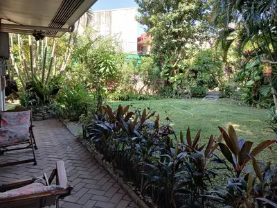 a garden with a chair and a lawn with plants at Casa Joaquin BnB in Manila