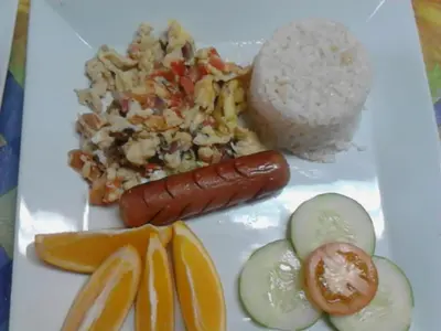 a plate of food with rice and a hot dog and vegetables at Casa Joaquin BnB in Manila