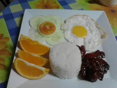 a plate of food with eggs and fruit on a table at Casa Joaquin BnB in Manila