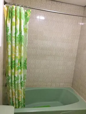 a bathroom with a tub with a shower curtain at Casa Joaquin BnB in Manila