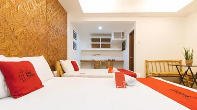 a bedroom with a bed and a living room at RedDoorz at DBuilders Rooms Ph1 Taguig in Manila