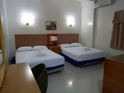 a hotel room with two beds and a table at Asia Novo Boutique Hotel - Rosario in Rosario