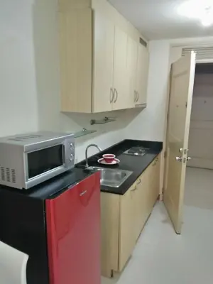 a kitchen with a microwave and a red refrigerator at CHATEAU ELYSSE a4 near SM Mall,AIRPORT Wifi in Manila